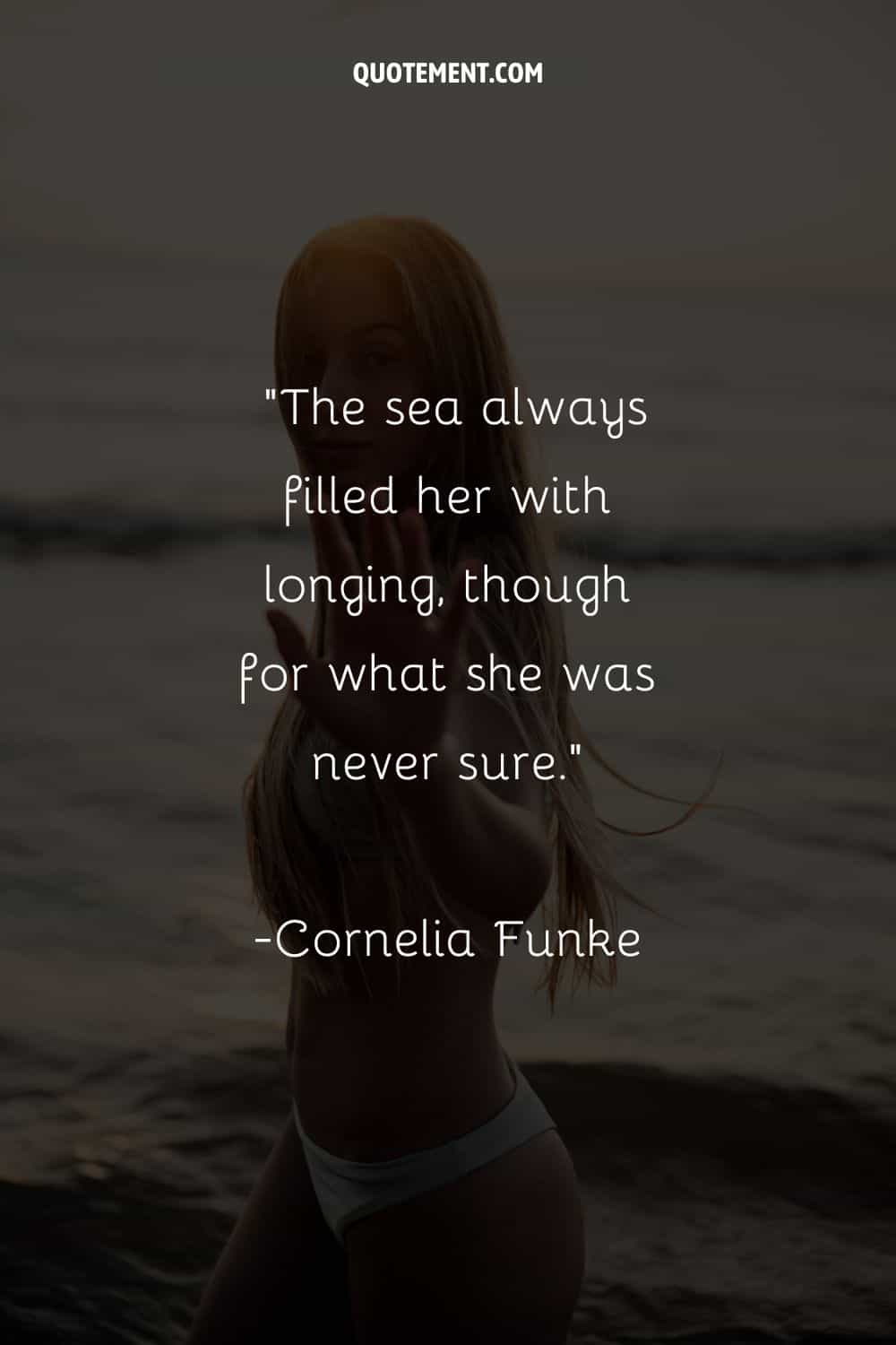 Girl with long hair standing in the water representing a quote about the sea.
