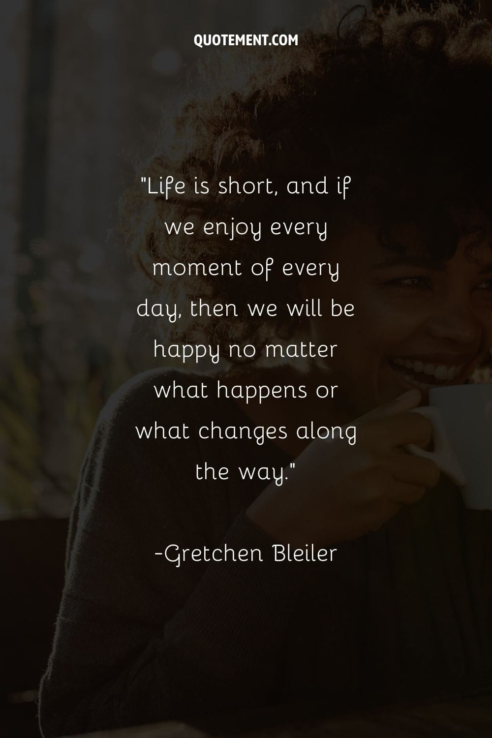 a young black woman holding a coffee mug and smiling representing a powerful enjoying every moment quote