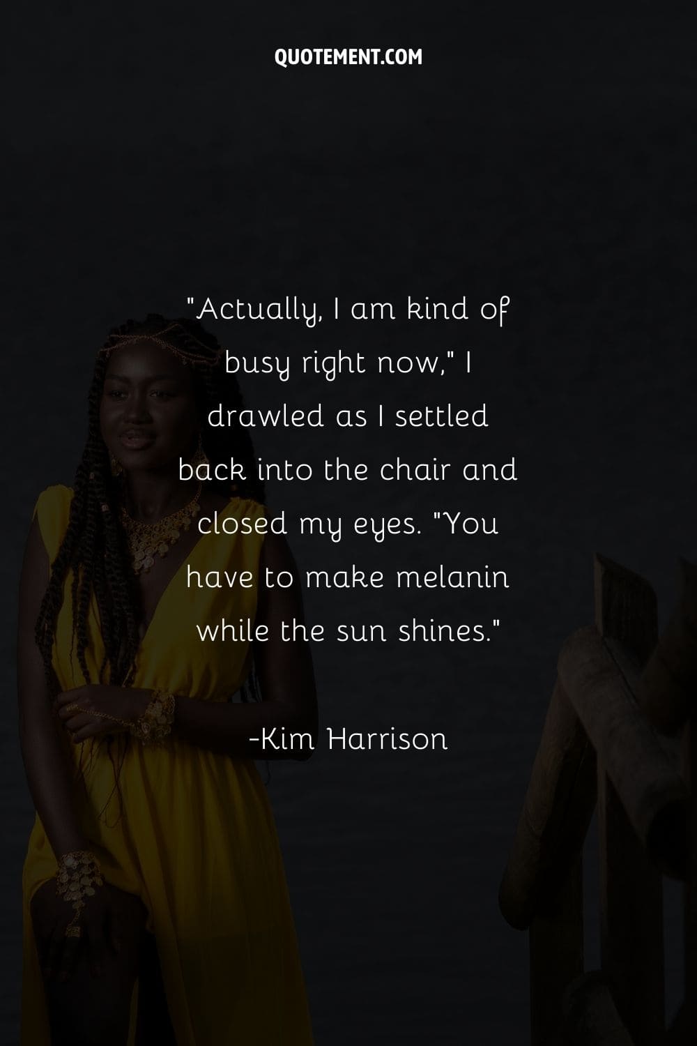 young black woman in a yellow dress and golden jewelry by the sea
