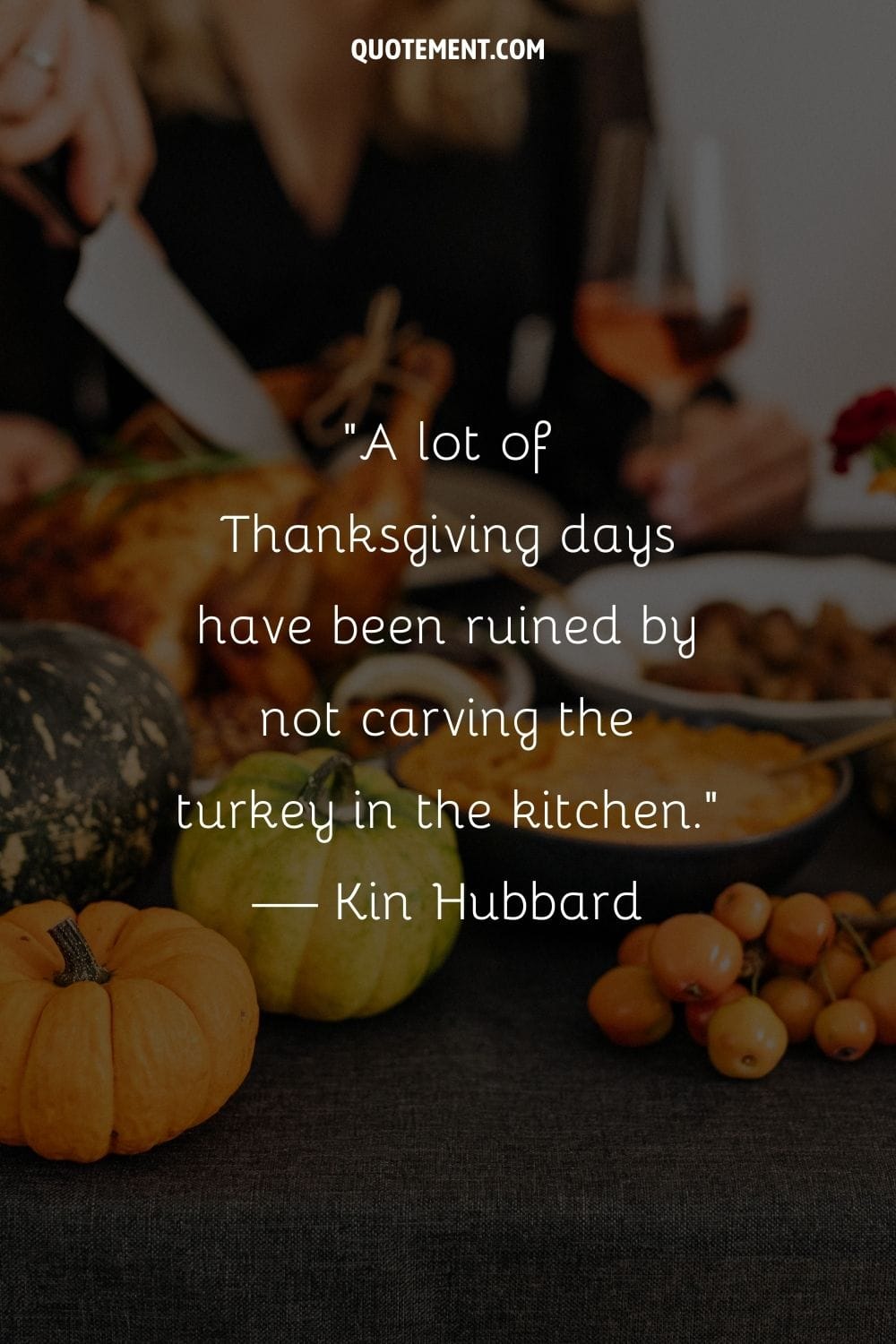 a hand slices the Thanksgiving turkey amidst pumpkin decor