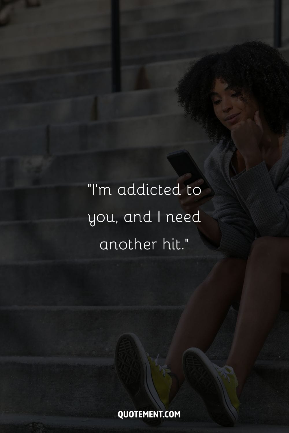 black woman on the stairs, focused on her phone