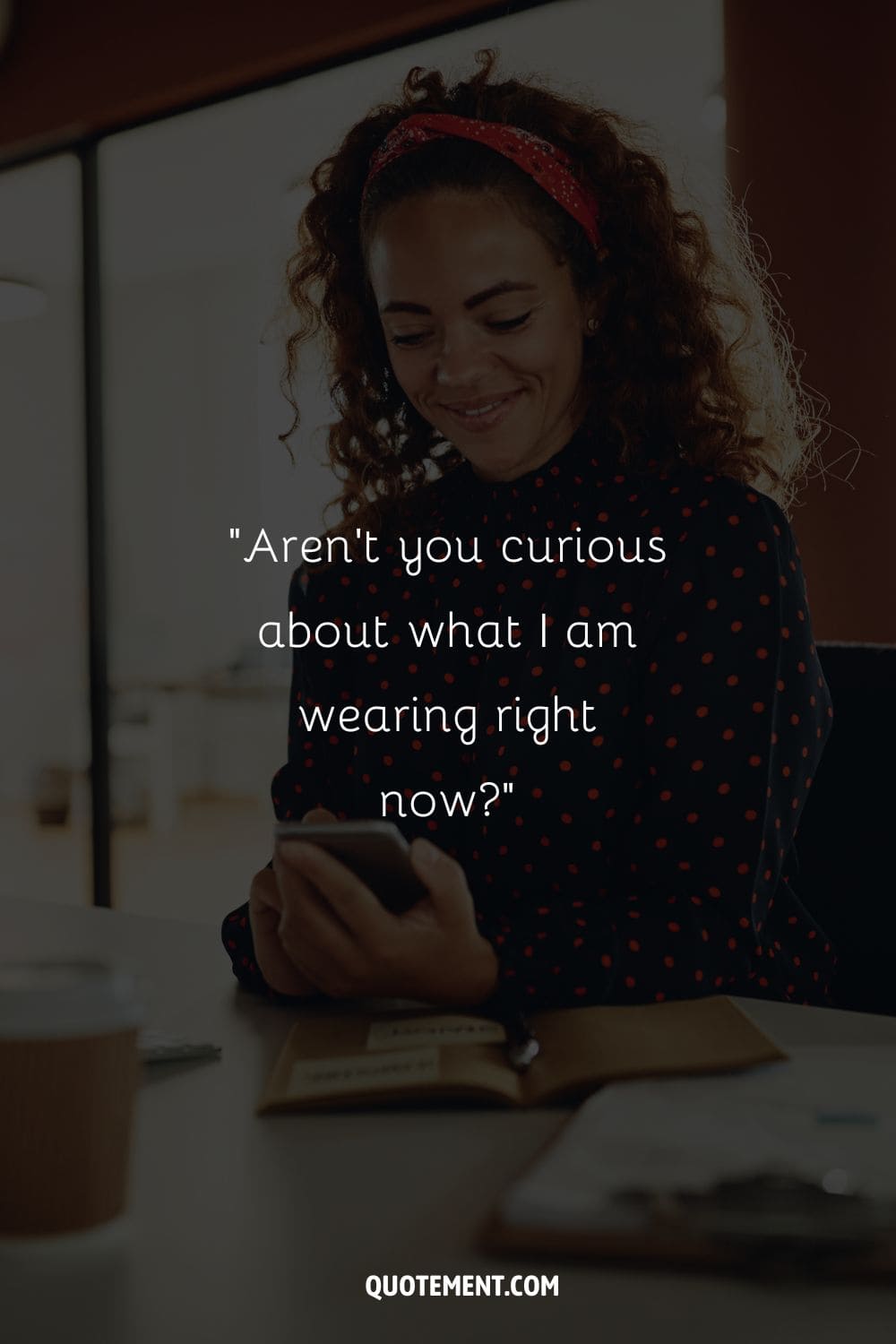 smiling black woman at her desk, phone in hand