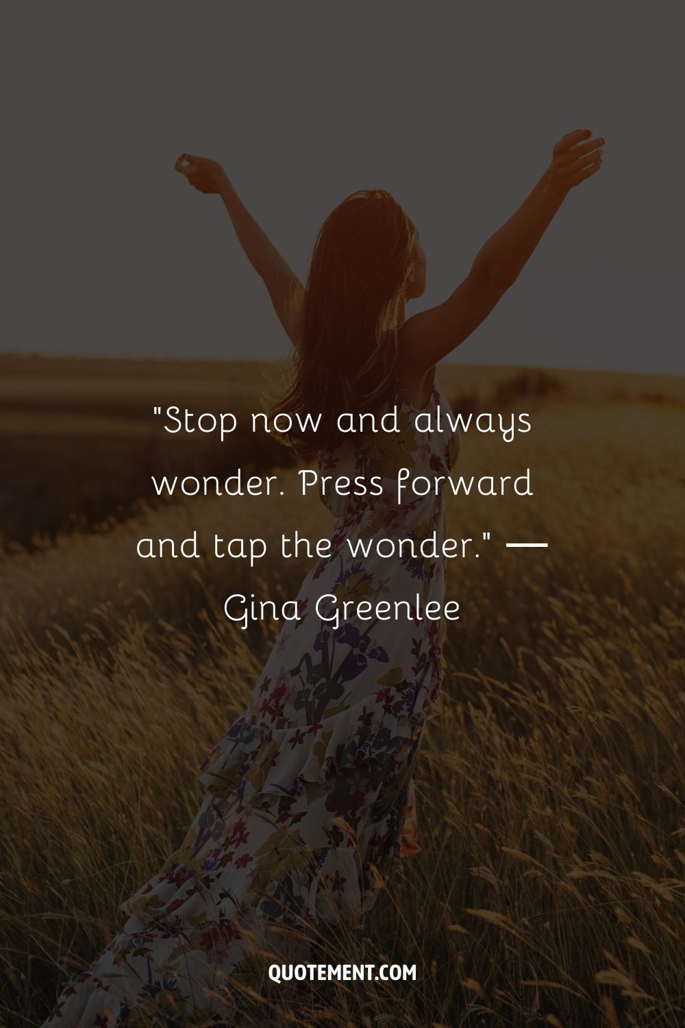 A woman standing in a field with arms raised representing the greatest keep going quote