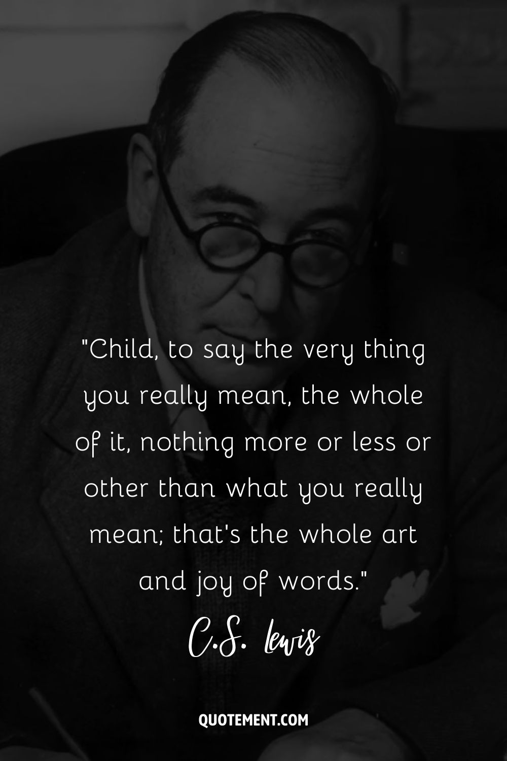 C.S. Lewis sitting with pen in hand and glasses on