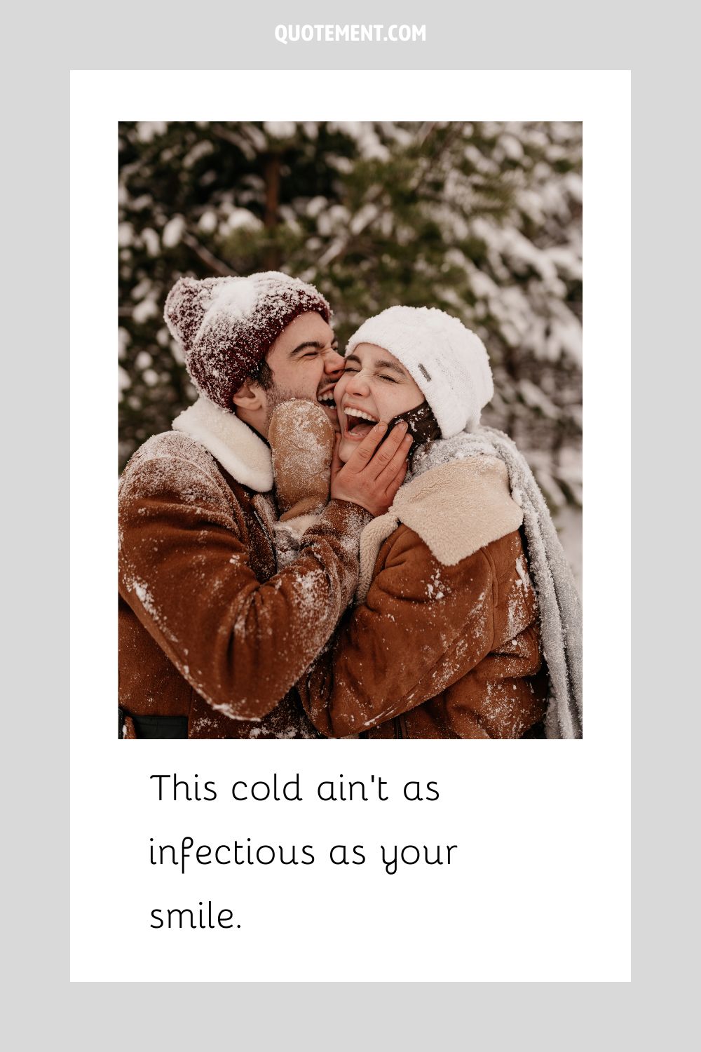a couple grins with happiness while sharing a loving embrace in a snowy scene