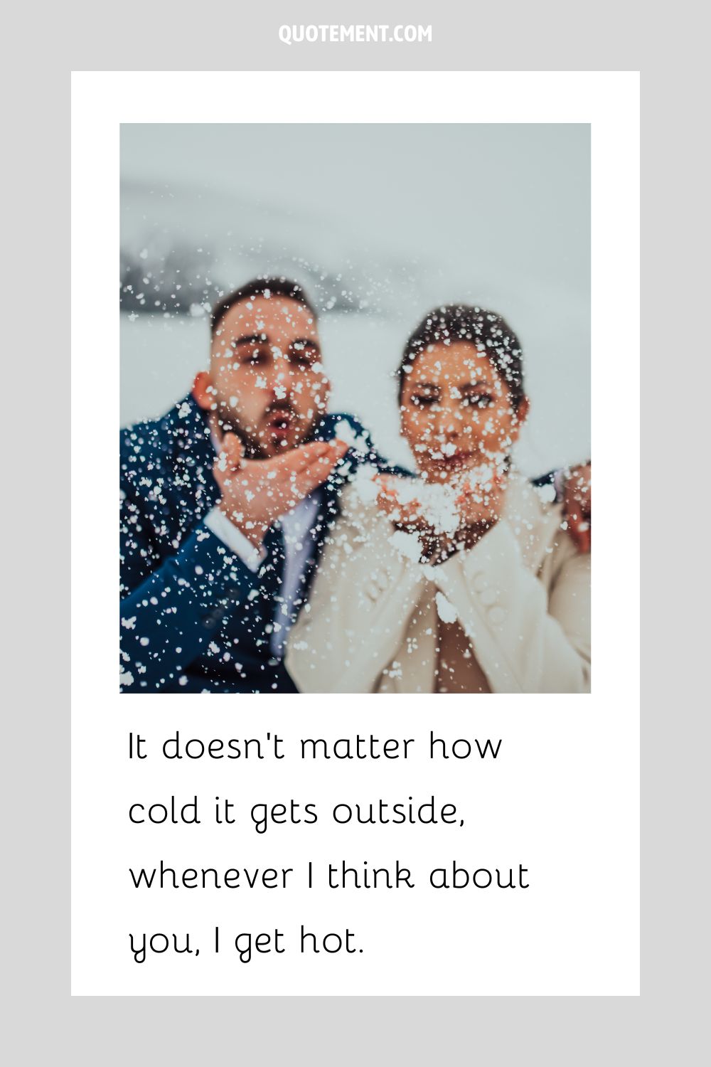 a smiling couple blows snow dust off their hands