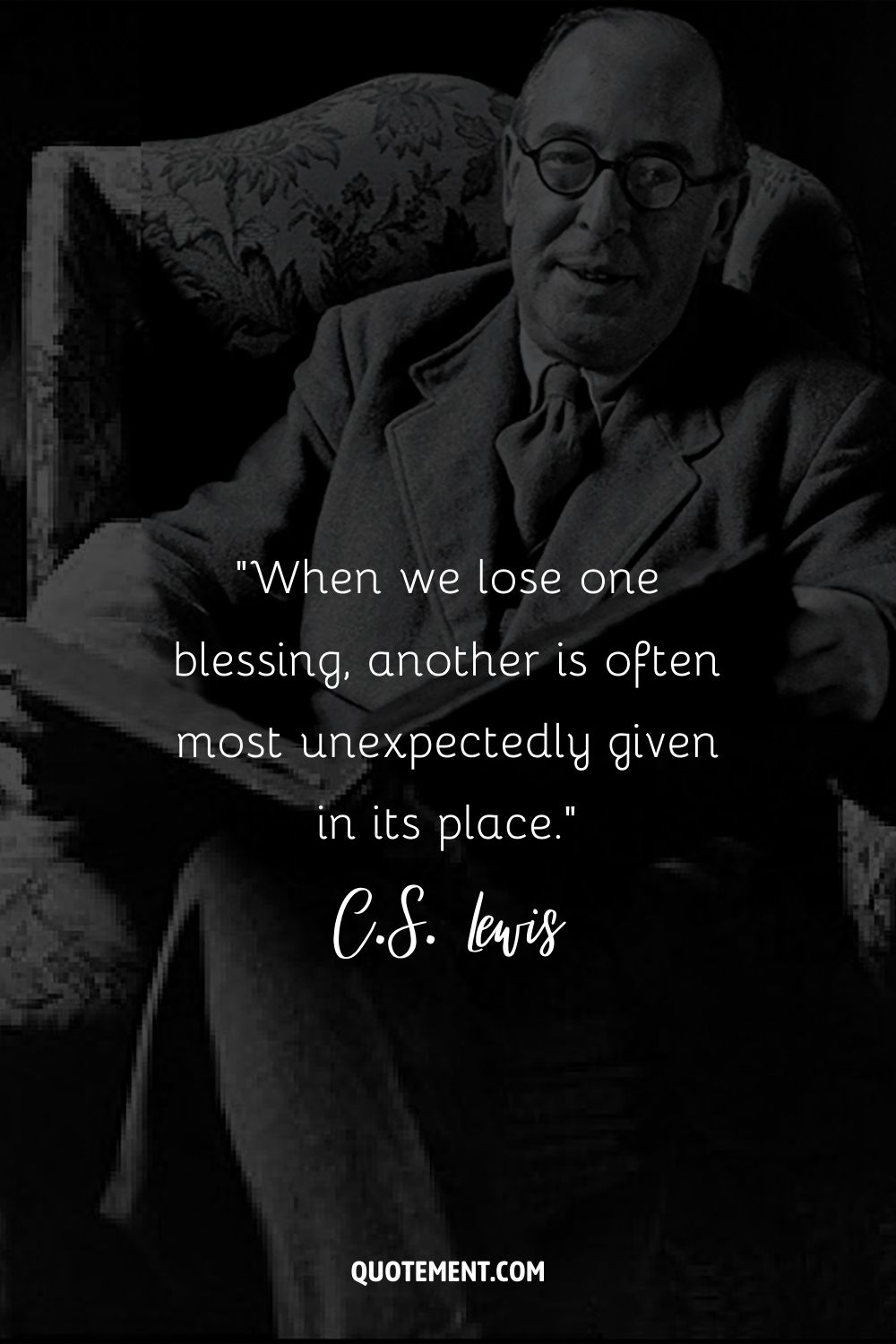 seated in a chair, C.S. Lewis smiles gently while holding a book