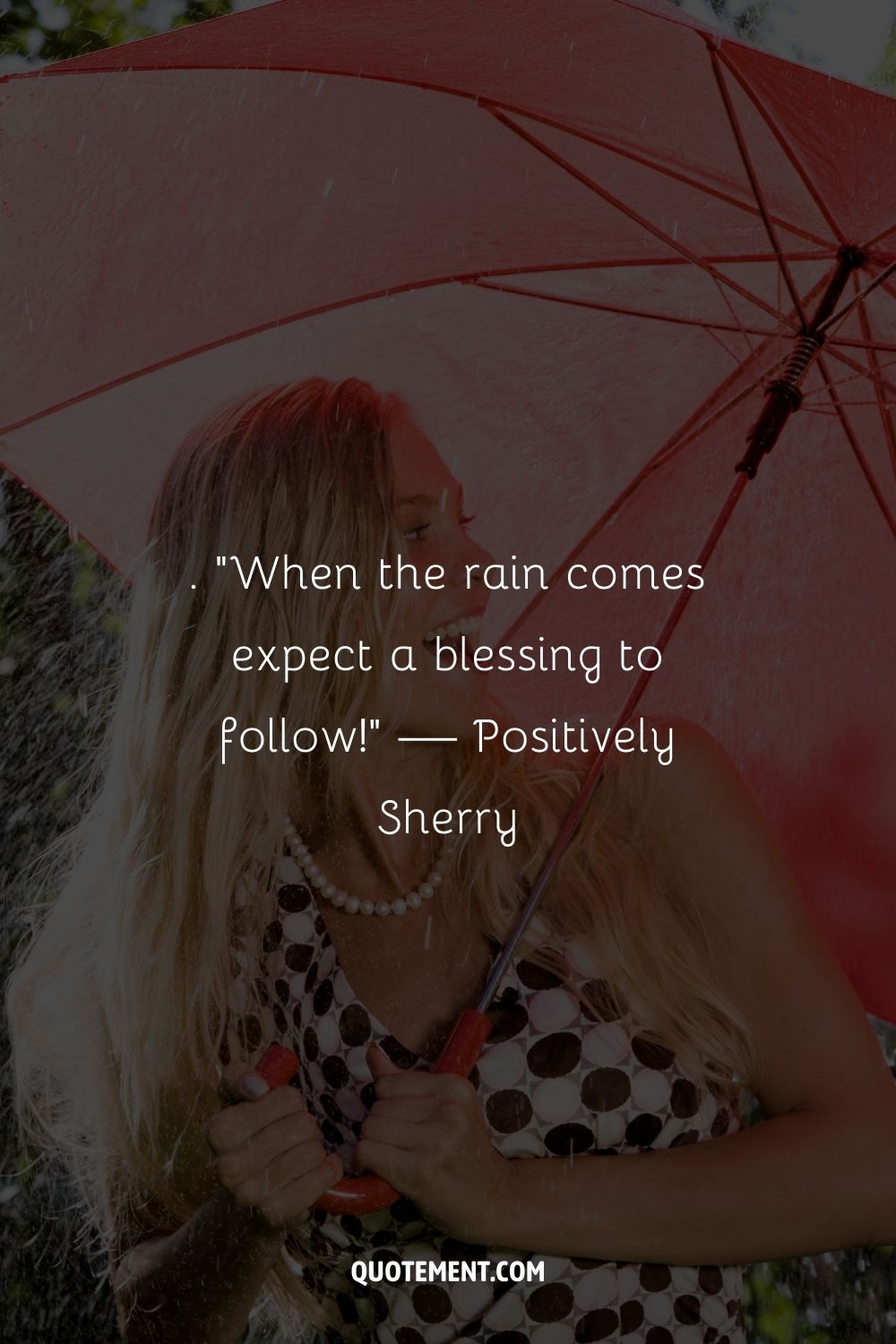 A blonde woman using a red umbrella for protection
