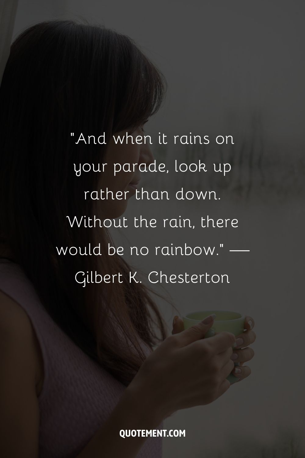 A close-up of a woman holding a mug and facing a window on a rainy day
