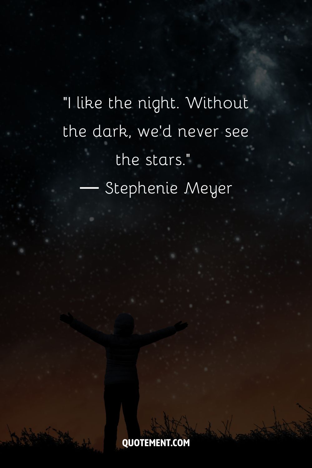 A person with spread arms under a night sky
