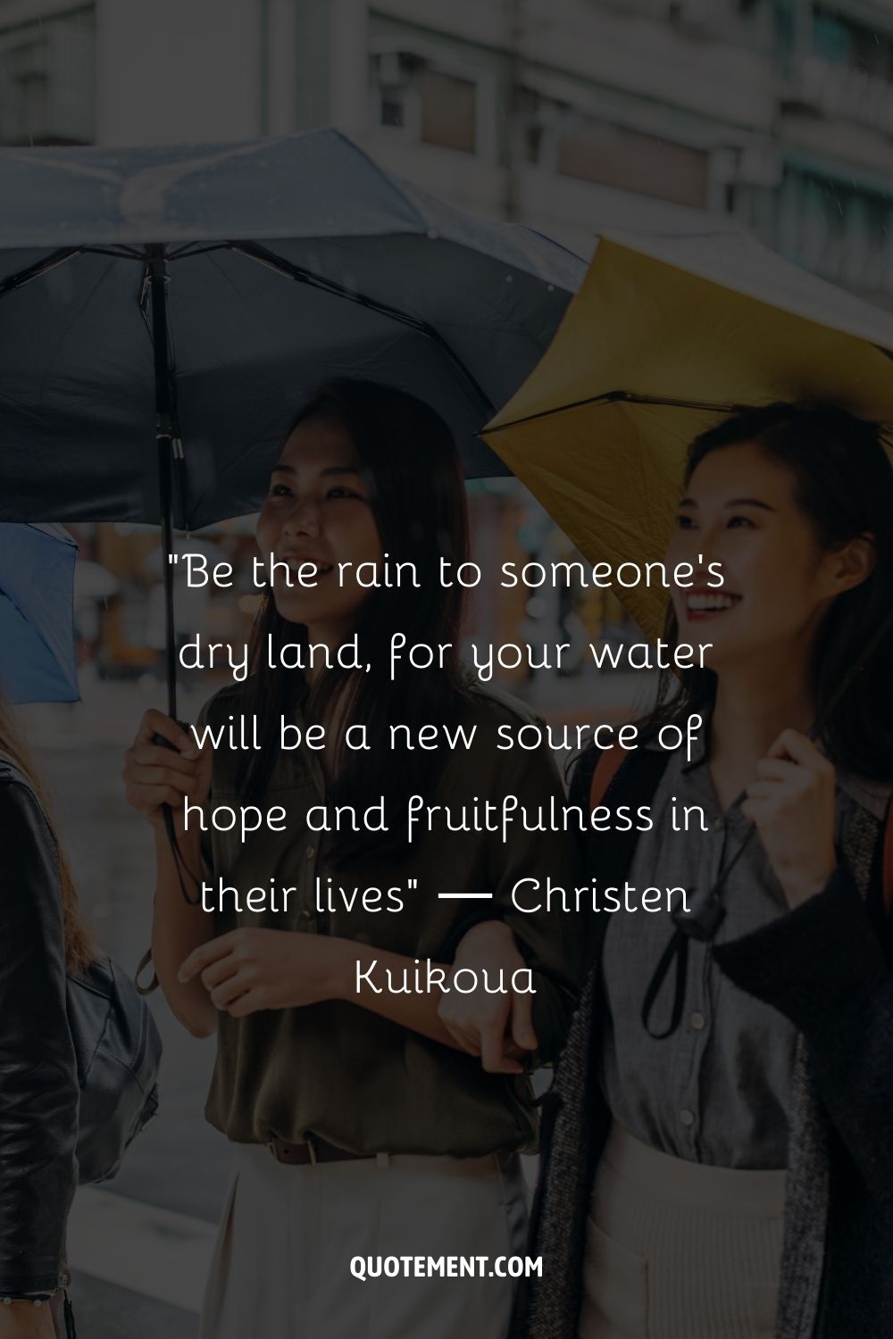 Two women smiling and using umbrellas on a wet day
