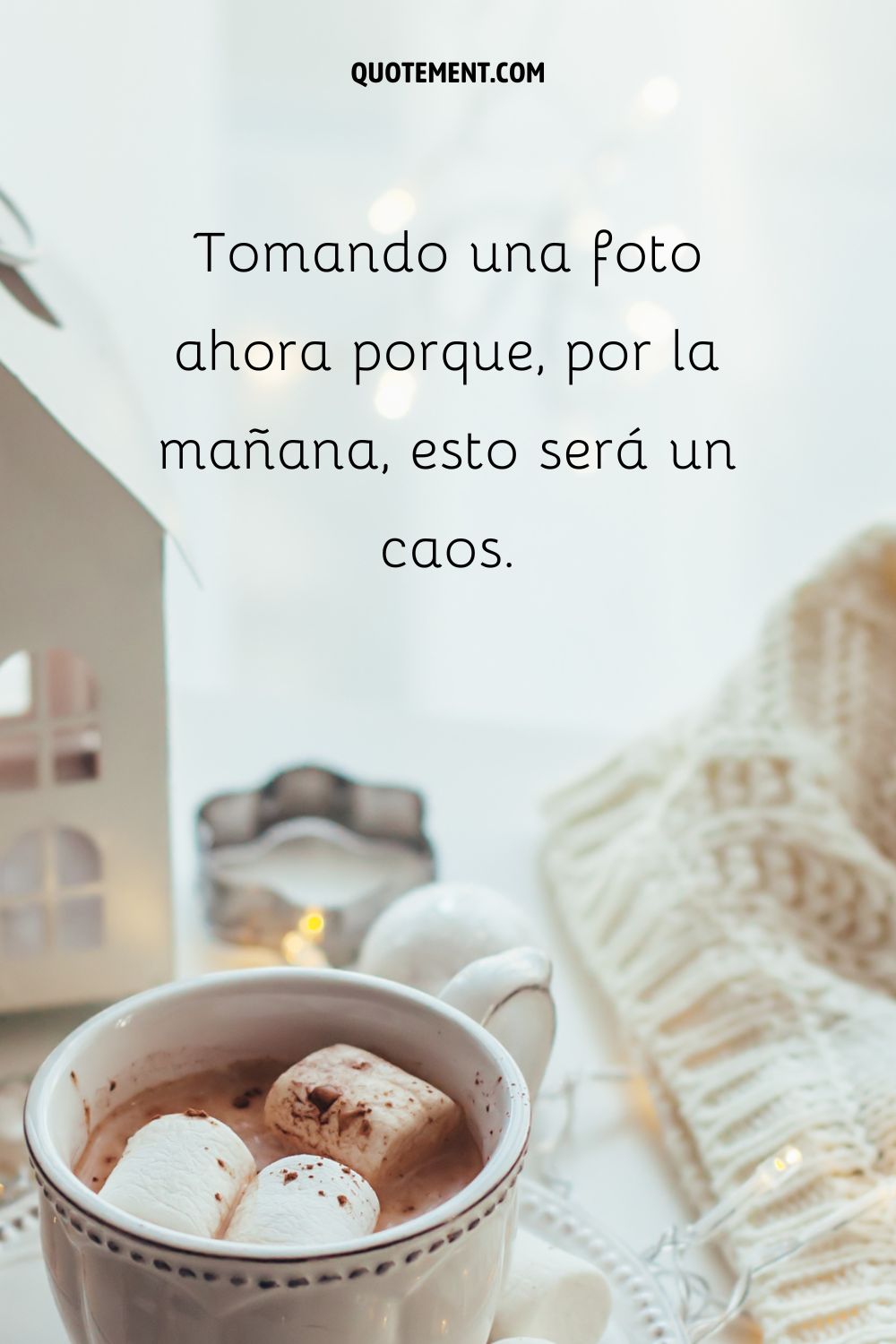 Una taza de chocolate caliente con malvaviscos y prendas de punto calientes de fondo