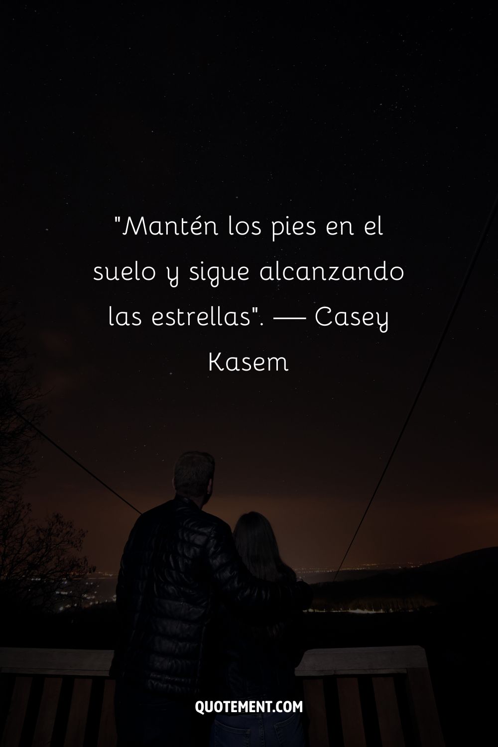 Una pareja contempla un cielo estrellado que representa una inspiradora cita de alcanzar las estrellas.