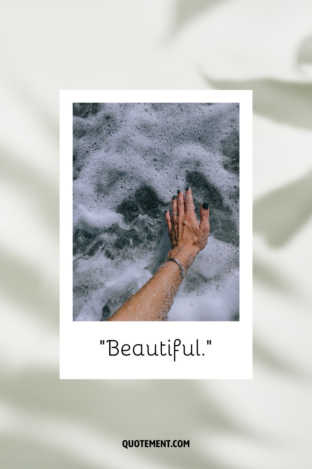 A woman's hand touching foamy water representing an inspiring one word quote

