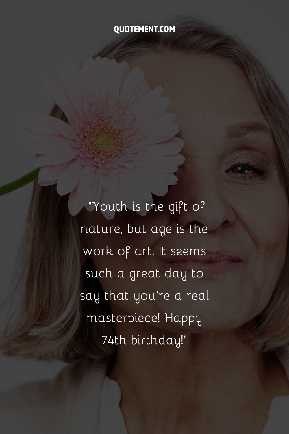 An older woman with a flower on her eye representing a perfect happy 74th birthday wish
