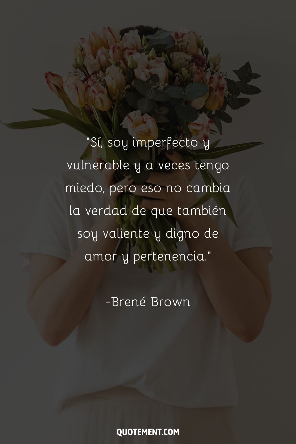 Una mujer sostiene un ramo de tulipanes frente a su cara que representa las 10 mejores citas de Brene Brown